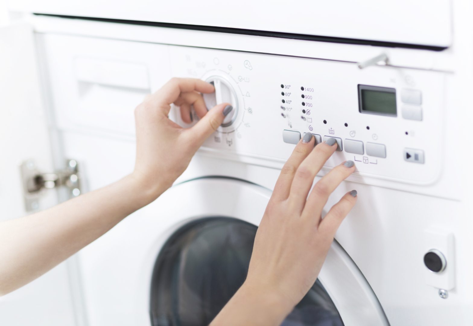 Woman changing washing machine settings after registering appliance