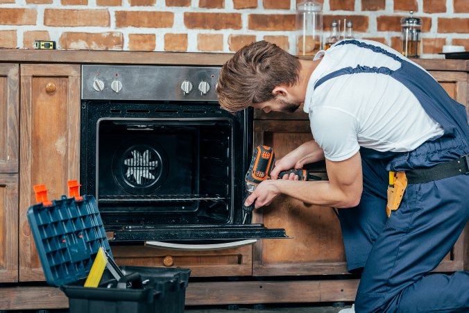 Electric engineer fixing oven